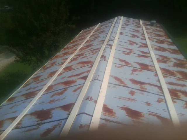 Rusted metal roof panels with new wood purlins before replacement — Storm Damage Roof Repair in Ripplemead by Roofing Brothers