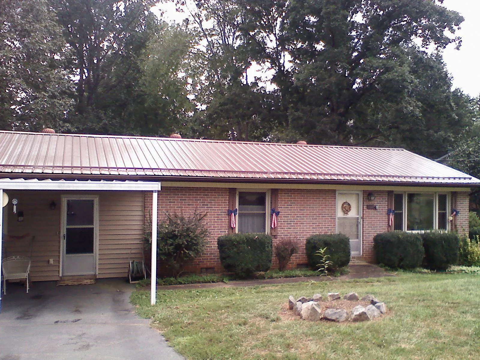 Bronze metal roof and carport on a brick ranch home — Roof Repair work by our crew in Ripplemead